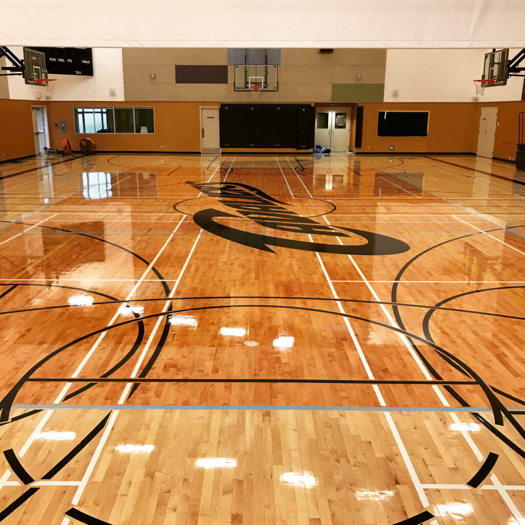 high school feature gym floor with side courts anda sedona stained volleyball court